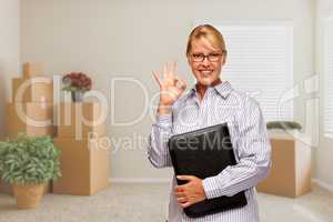 Woman with Okay Sign in Empty Room with Packed Moving Boxes
