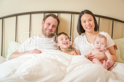 Mixed Race Chinese and Caucasian Baby Boys Laying In Bed with Th