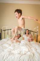 Mixed Race Chinese and Caucasian Boy Jumping In Bed with His Fam