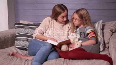 Mother and daughter reading story at home together