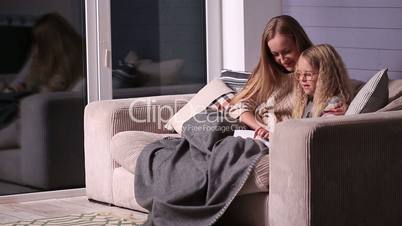 Mom teaching daughter to read at home