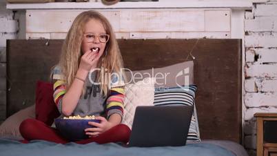 Little girl watching cartoons on laptop.