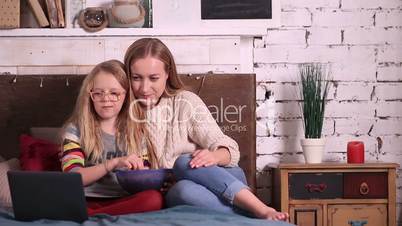 Mother and daughter watching cartoons on laptop