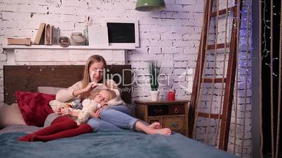 Young woman caressing her daughter to fall asleep