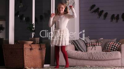 Dancing little girl with headphones at home