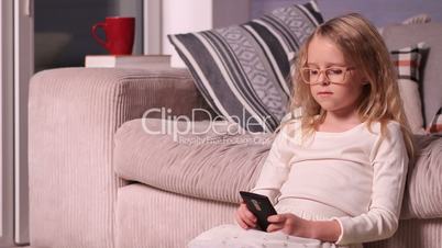 Beautiful little girl playing with smartphone