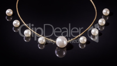 White pearls necklace on black background