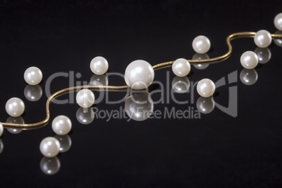 White pearls necklace on black background