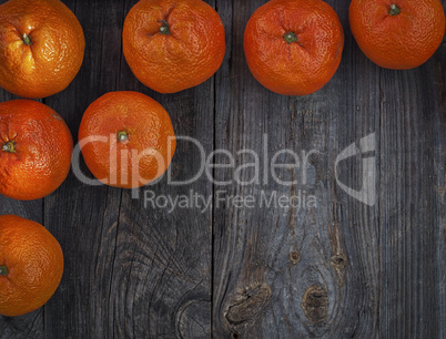 Orange mandarins on the gray old wooden surface, top view