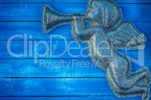 Figure angel of shiny particles on a blue wooden background