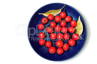 Hawthorn berries on a plate on a white background.