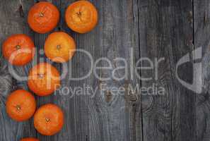 Ripe orange mandarins on the gray wooden background