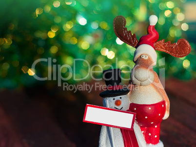 Christmas Elk with a snowman standing on a blurred background