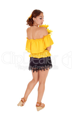 Woman with sunflowers looking over shoulder.