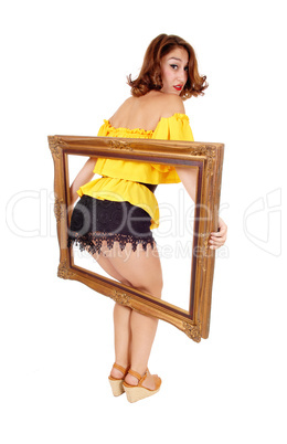 Woman putting her butt trough frame.