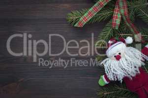 Brown wood background with rag Santa Claus and fir branch