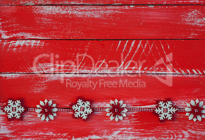 Garland with felt snowflakes on red shabby wooden surface