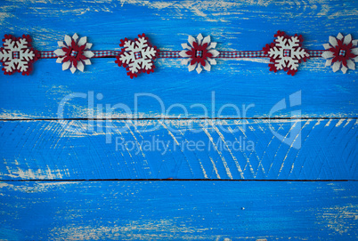 felt snowflakes on a blue wooden surface