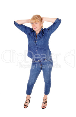 Woman standing  with booths hands on head.