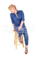 Blond woman sitting on chair.