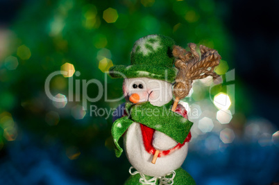 Christmas snowman on the background of blurred lights green tree