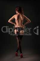 Rear view of topless seductive woman in stockings