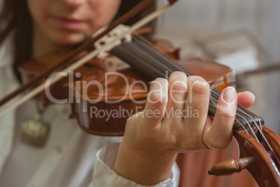 Symphony orchestra on stage, hands playing violin. Shallow depth
