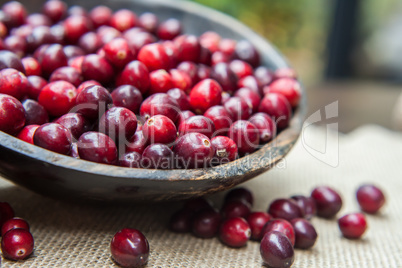 Fresh cranberries  in rustic wooden bowl on burlap Background an