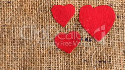 Three red heart shapes on jute