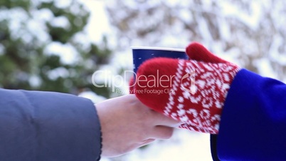 Man giving paper cup of coffee to woman in winter