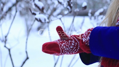 Woman warming frozen hands in mittens