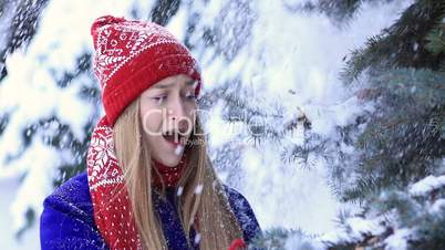 Happy woman in winter forest getting snow shower