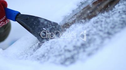 Winter driving - scraping ice from a windshield