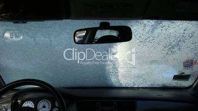 Cleaning car window with an ice scraper