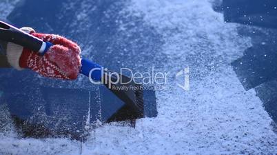 Scraping ice from car's front windshield window