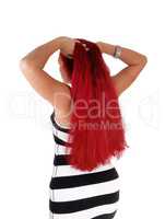 Woman with red hair standing from back.
