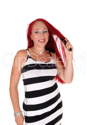 Woman brushing her red hair.