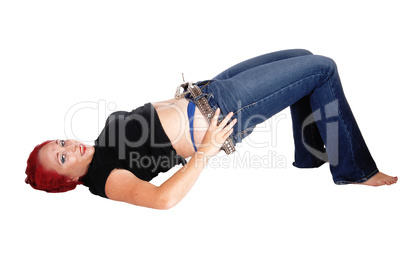 Woman lying on floor pulling jeans up.