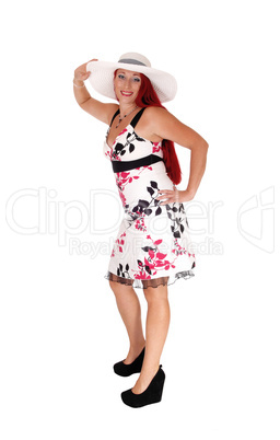 Red haired woman standing with hat.