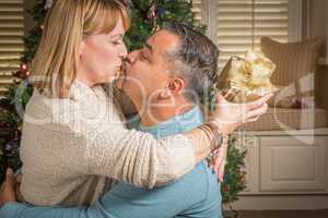 Young Mixed Race Couple with Present Near Christmas Tree