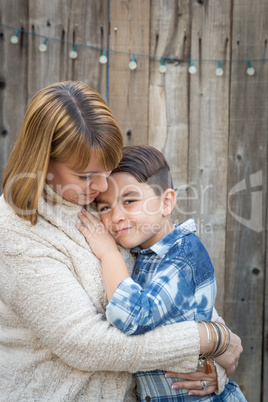 Mother and Mixed Race Son Hug Near Fence