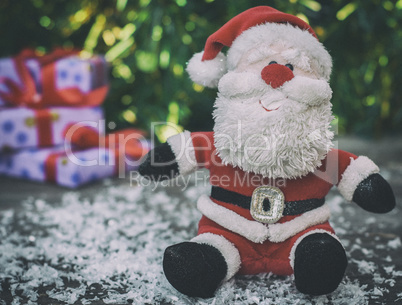 Santa Claus on a gray wooden surface with snow