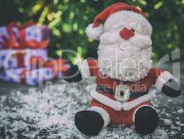 Santa Claus on a gray wooden surface with snow