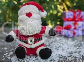 Santa Claus on a gray wooden surface with snow