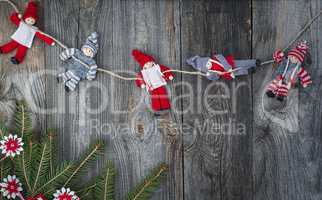 Rag Doll Christmas hanging on the rope on gray old wooden surfac