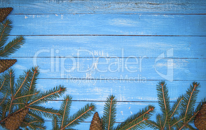 Spruce branches on blue wooden surface Christmas background, vin