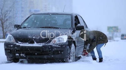 Woman shoveling and removing snow from her car