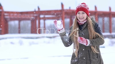 Winter woman playing in snow throwing snowballs