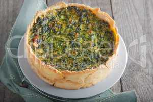 Spinach quiche - vegetable pie on a wooden surface