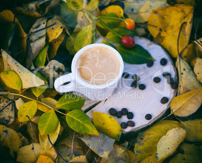 White cup with espresso coffee on a wooden stump